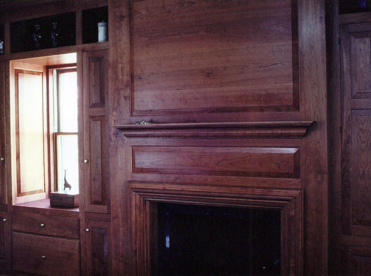 Fireplace surround with traditional cherry cabinetwork and mill work