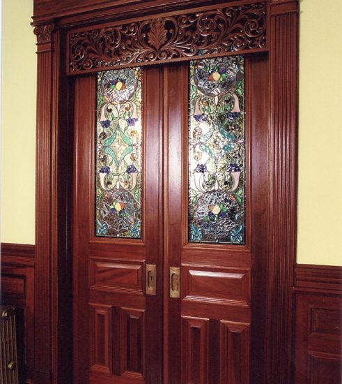 Pocket mahogany doors with stained glass and carved frieze