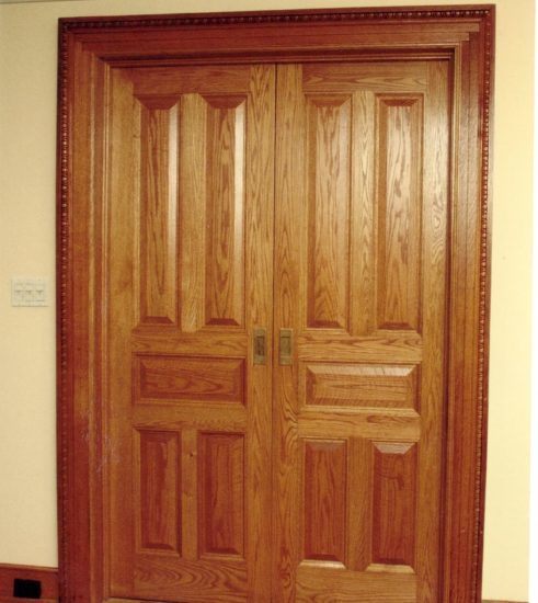 Traditional five-panel pocket doors in red oak with “egg and dart” molding on casing. Brooklyn, NY